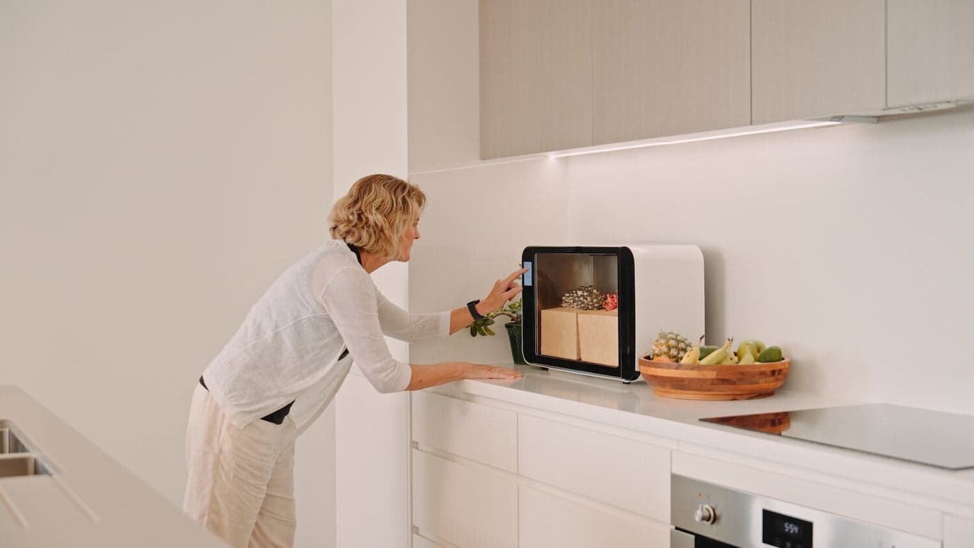 A woman checking on the Flush cabinet in a calm, minimal kitchen