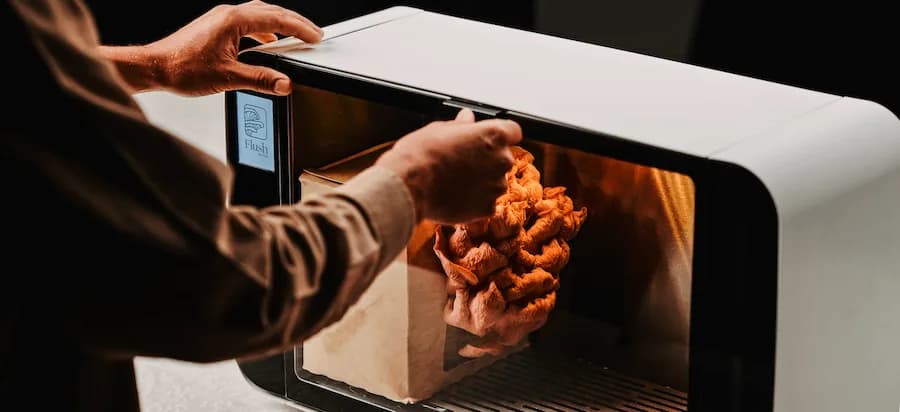 A hand reaching into the warm glow of the Flush cabinet as mushrooms fruit