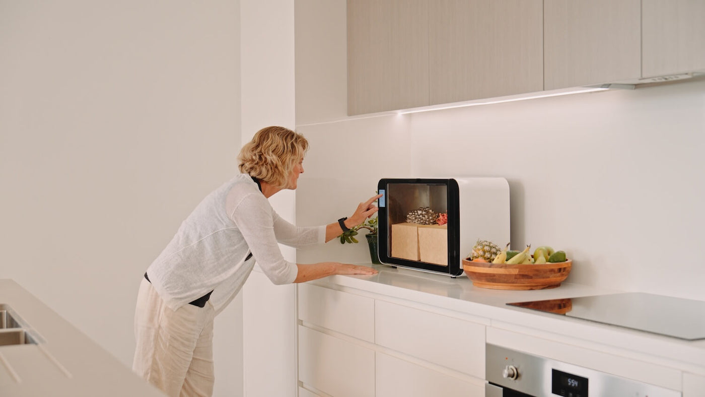 A woman checking on the Flush cabinet in a calm, minimal kitchen